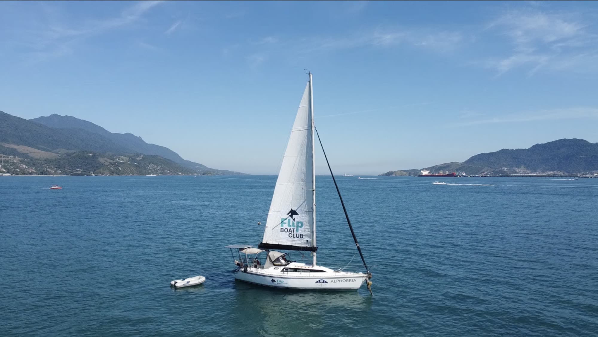 Veleiro Alphorria, do Flip Boat Club, navegando com a vela estampada da marca