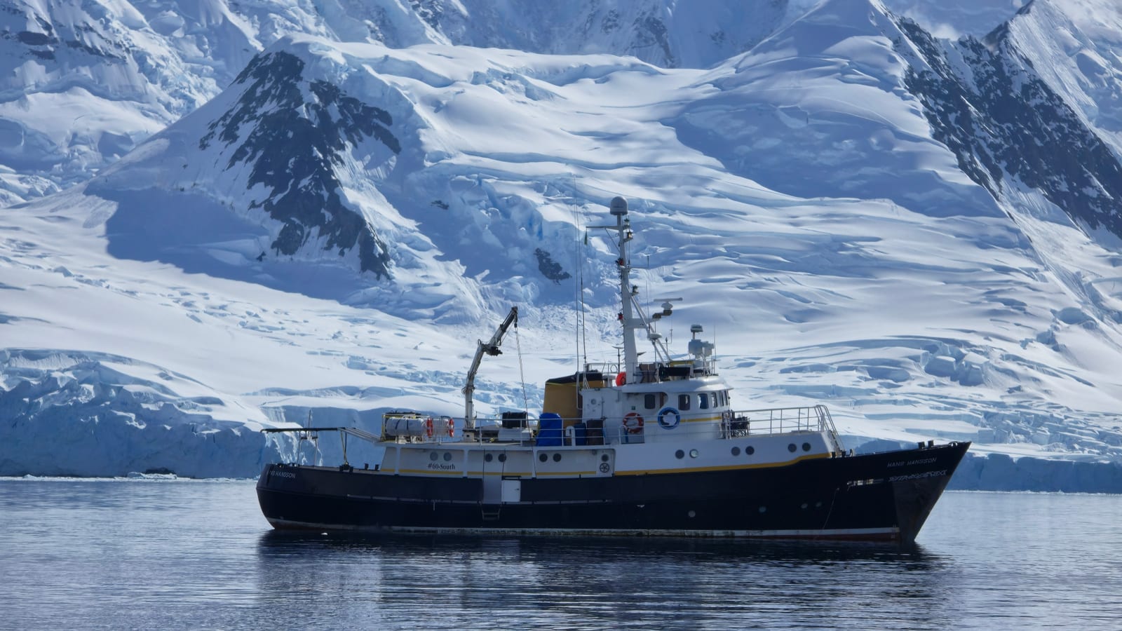 O Hans Hansson fundeado diante de montanhas cobertas de neve, nas Ilhas Shetland do Sul