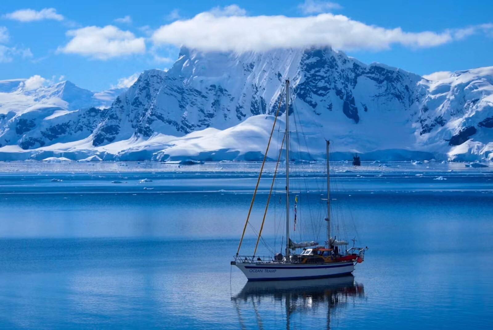 Veleiro Ocean Tramp ancorado na Antártica diante de montanhas nevadas