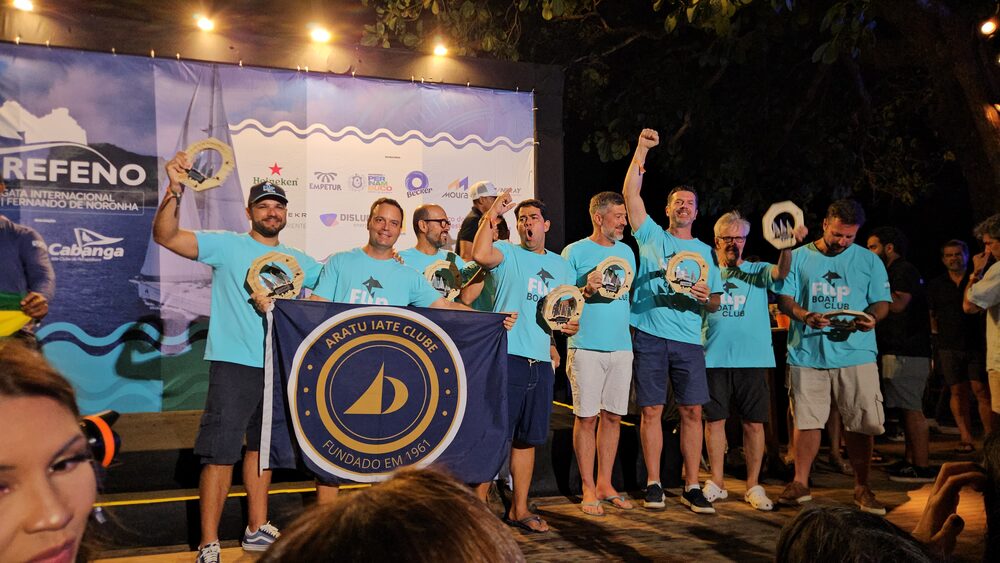 Equipe Flip no pódio da Refeno com a bandeira do Aratu Iate Clube