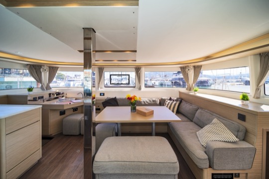 Salão interno do catamarã, com cozinha e mesa de refeições