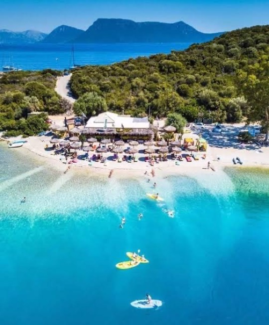 Praia de águas transparentes em Meganisi, com caiaques