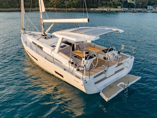 Monocasco à vela navegando em águas calmas, visto do alto